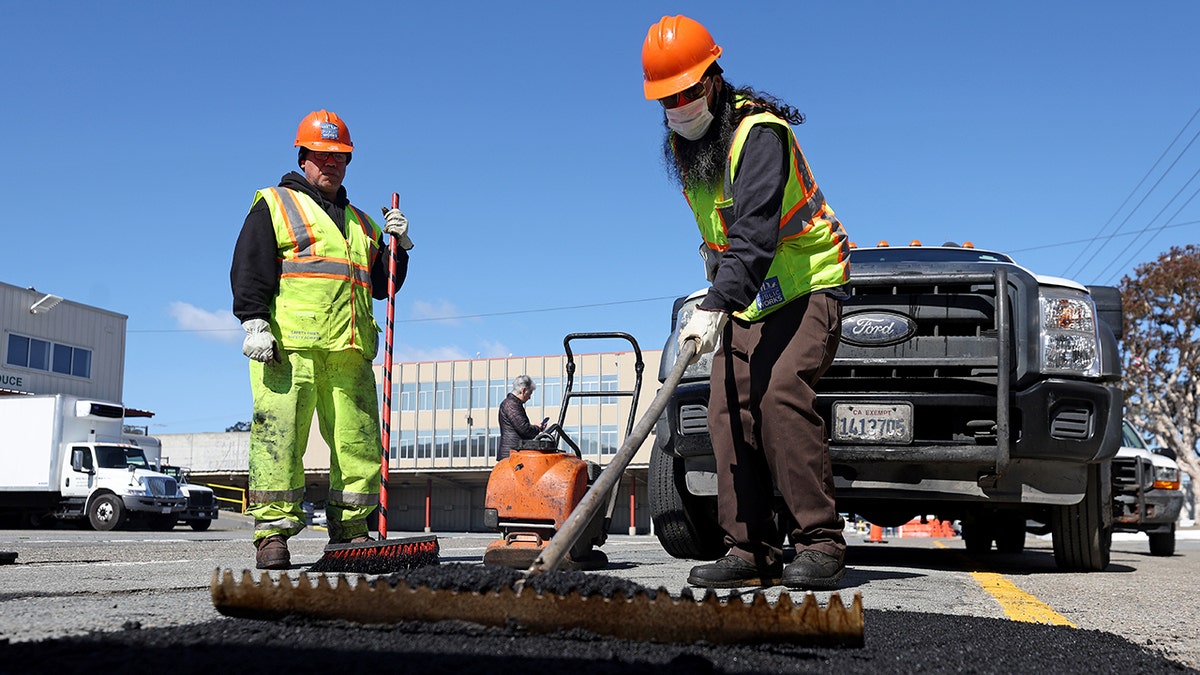 San Francisco public workers repair pothole